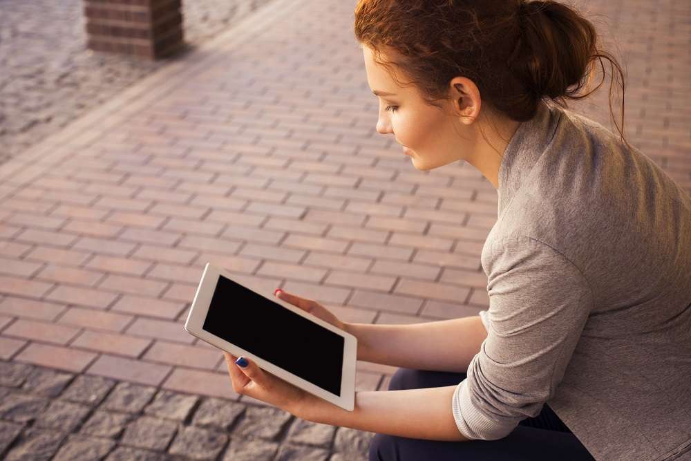 Woman Looking at a tablet reading (20%)